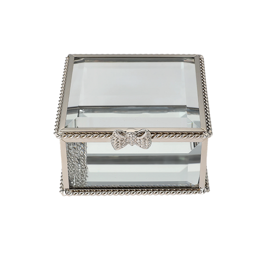 Glass jewelry box with silver decorative bow on a white background
