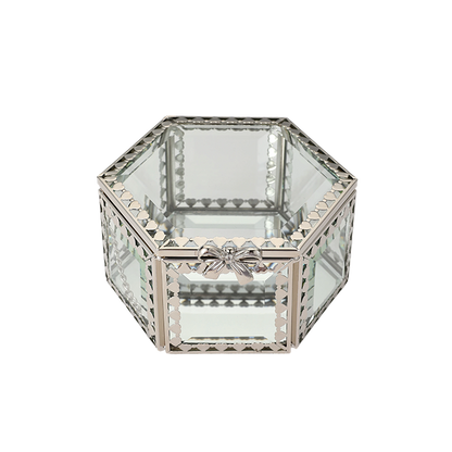 Hexagonal glass box with decorative metal frame on a white background