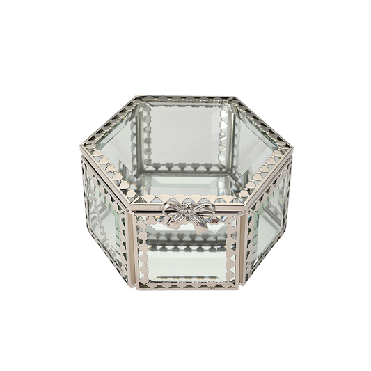 Hexagonal glass box with decorative metal frame on a white background