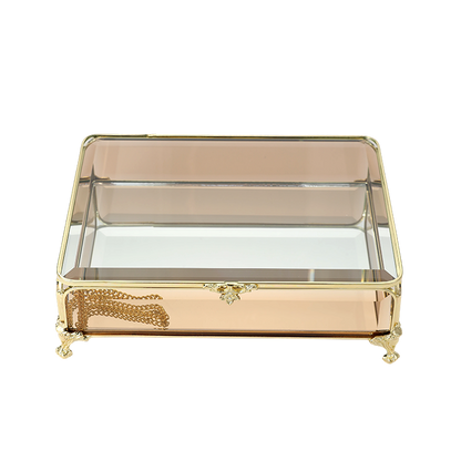 Decorative glass box with gold accents on a white background