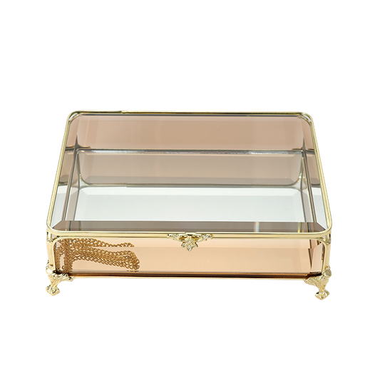 Decorative glass box with gold accents on a white background