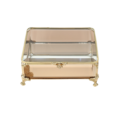 Decorative glass box with gold accents on a white background