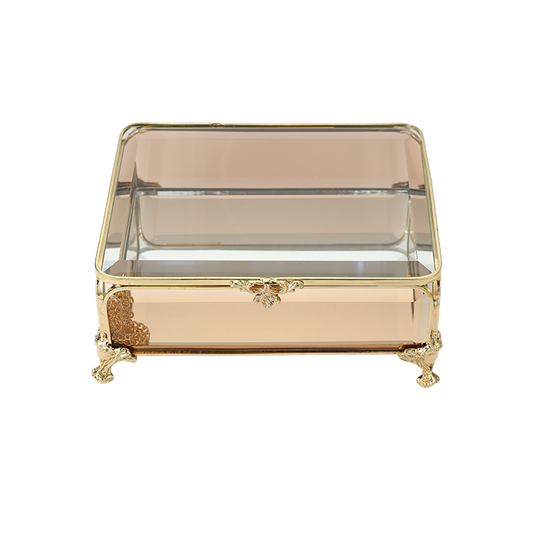 Decorative glass box with gold accents on a white background