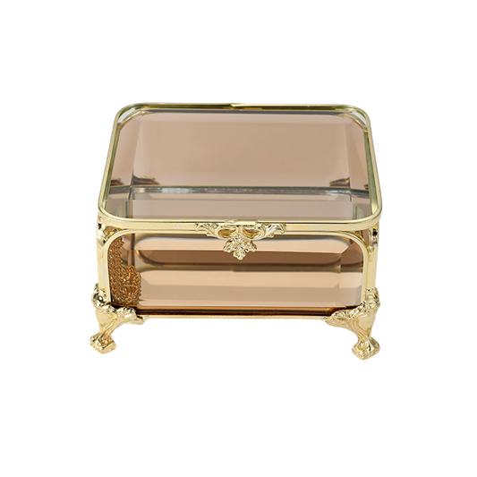 Decorative glass box with gold frame and legs on a white background