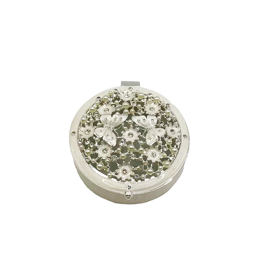 Round decorative box with floral embellishments on a white background