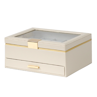 Beige jewelry box with a glass top and gold accents on a white background