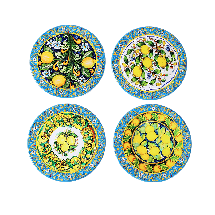 Set of four ceramic plates with lemon and floral designs on a white background