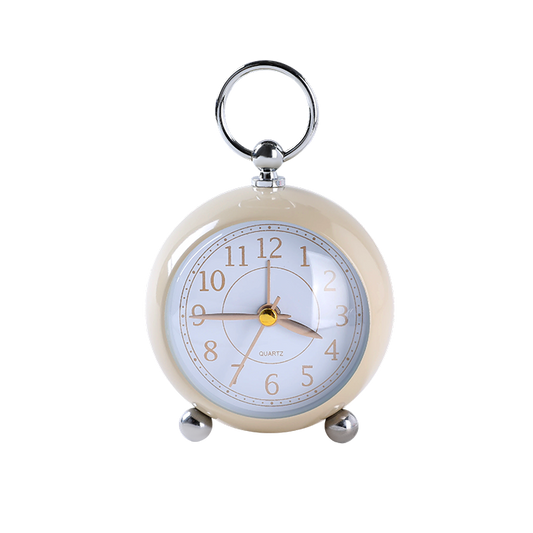 Small round alarm clock with a cream casing and silver accents on a white background