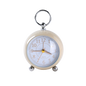 Small round alarm clock with a cream casing and silver accents on a white background