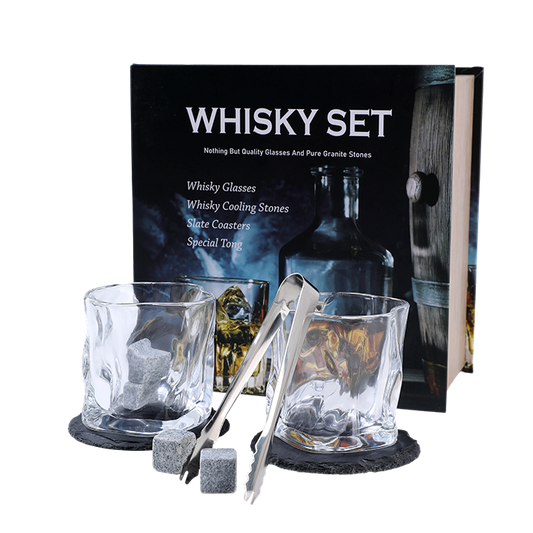 Whisky set with glasses, cooling stones, coasters, and a tong in front of a branded box.