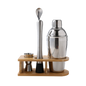 Set of cocktail-making tools including a shaker, jigger, and spoon on a wooden stand with a white background.